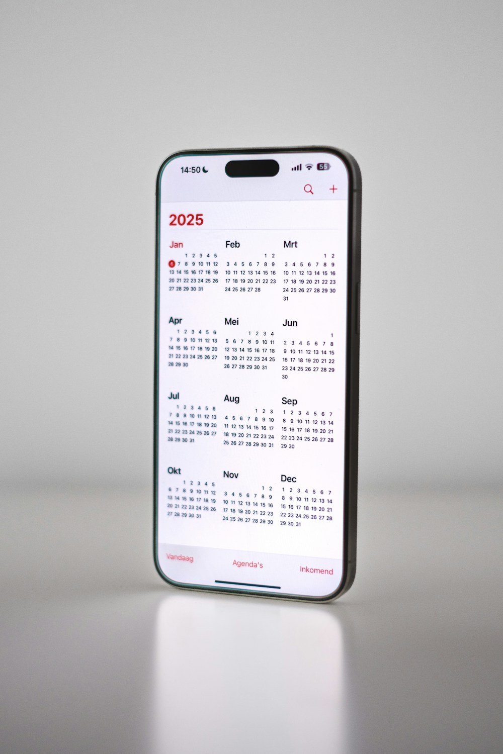 Como Organizar Gastos Mensais em 15 Minutos por Semana Celular com calendário simbolizando o registro semanal usado para organizar gastos mensais