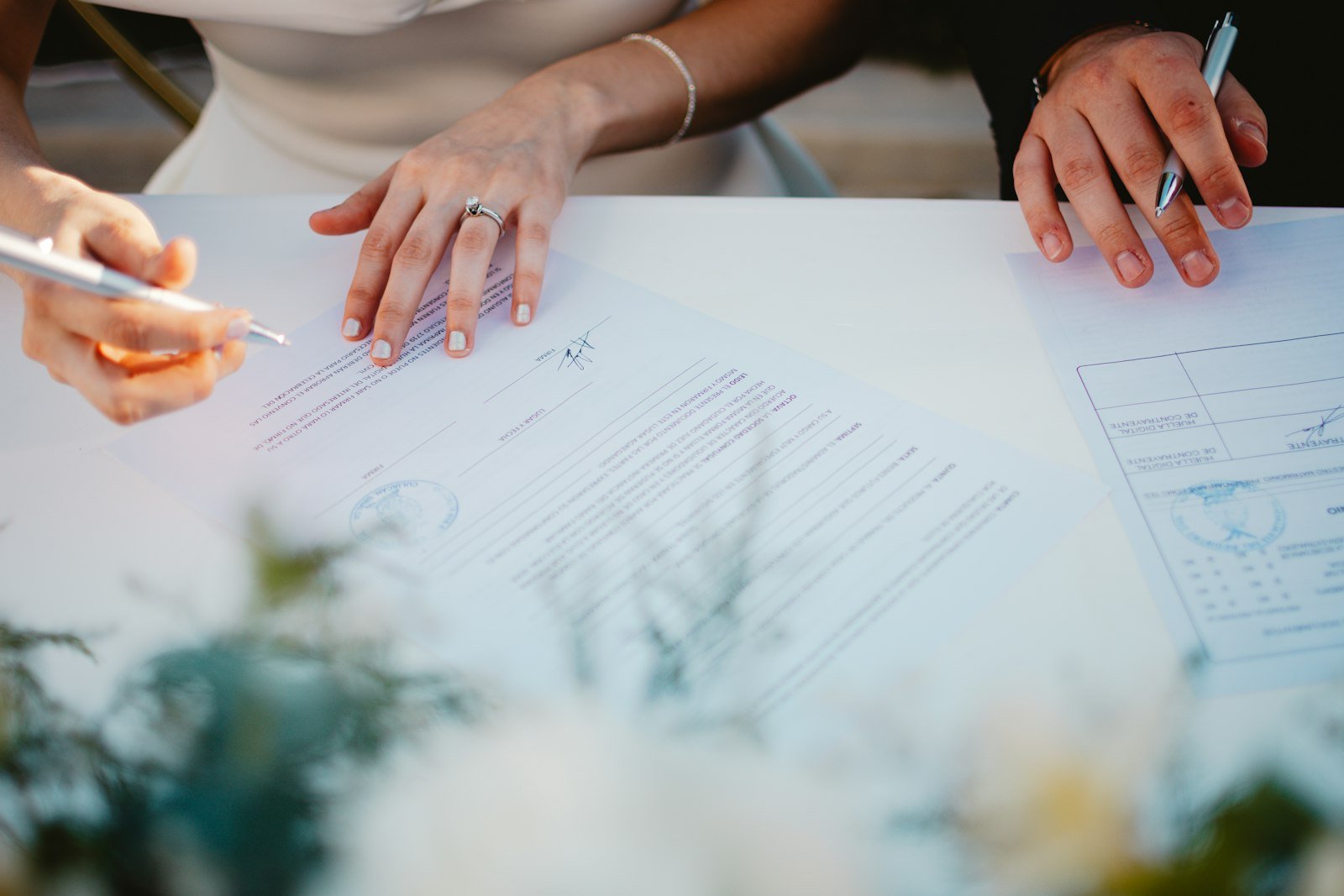 Casal organizando a planilha de gastos de casamento à mesa com documentos