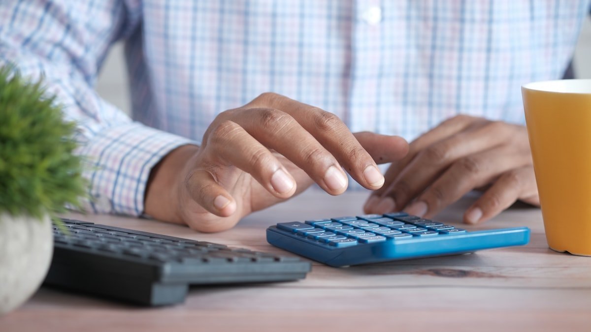 Capital de Giro: Quanto o Seu Negócio Precisa Para Não Faltar Calculadora e laptop na mesa para estimar a necessidade de capital de giro