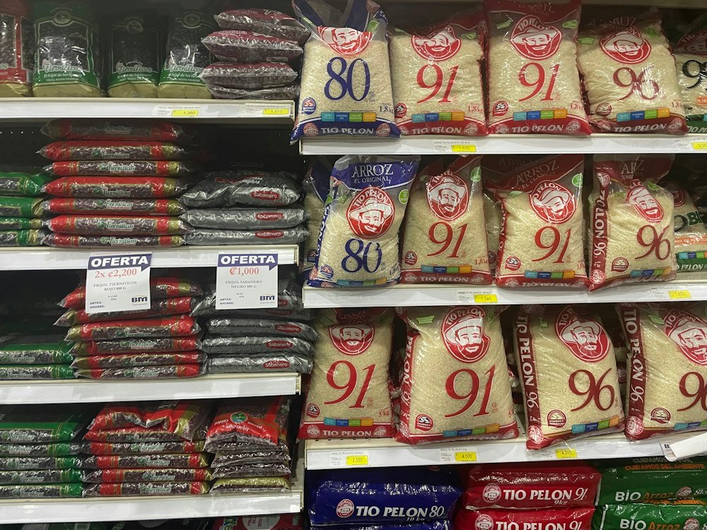 Corredor de supermercado com arroz e feijão em oferta, onde a inflação aparece primeiro