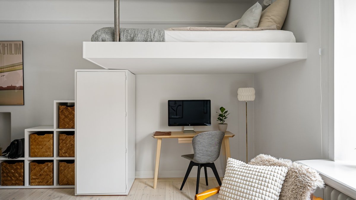 Quarto pequeno de quem vai morar sozinho, com cama e escrivaninha
