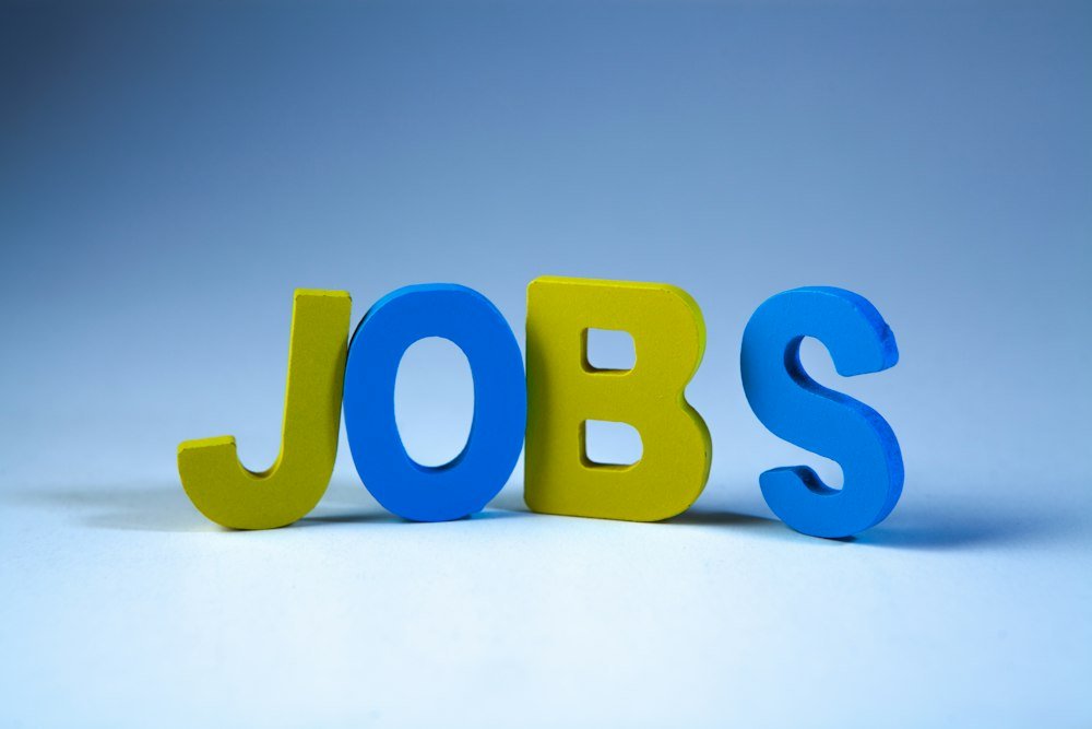 Como Funciona o Seguro-Desemprego: 3 a 5 Parcelas de Até R$ 2.518 Letras de madeira formando a palavra jobs, sobre a volta ao mercado de trabalho durante o seguro-desemprego