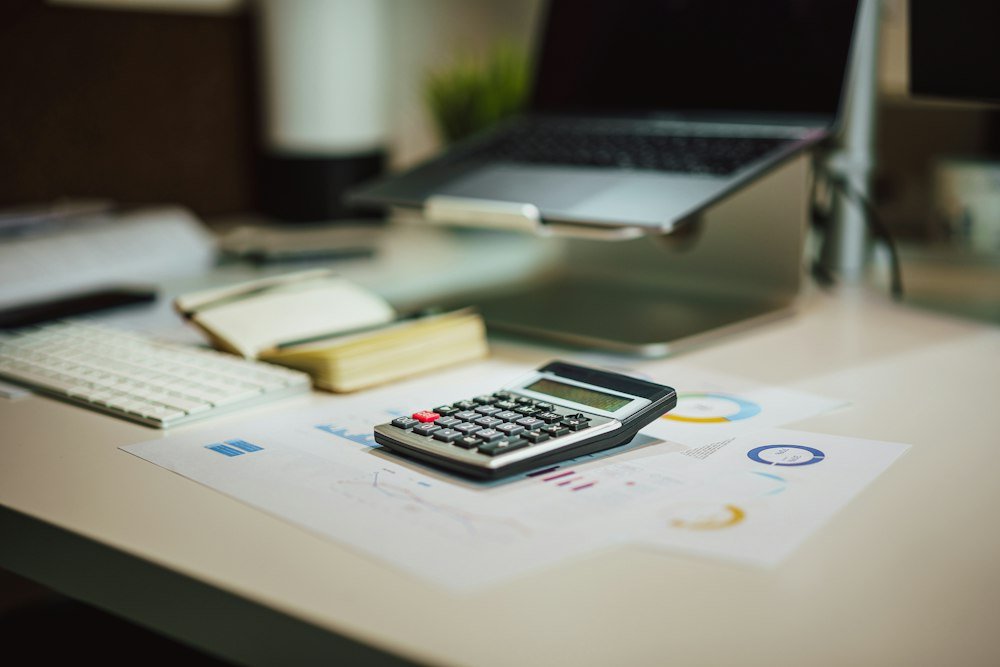 Calculadora ao lado do notebook para fazer o cálculo do aviso prévio indenizado