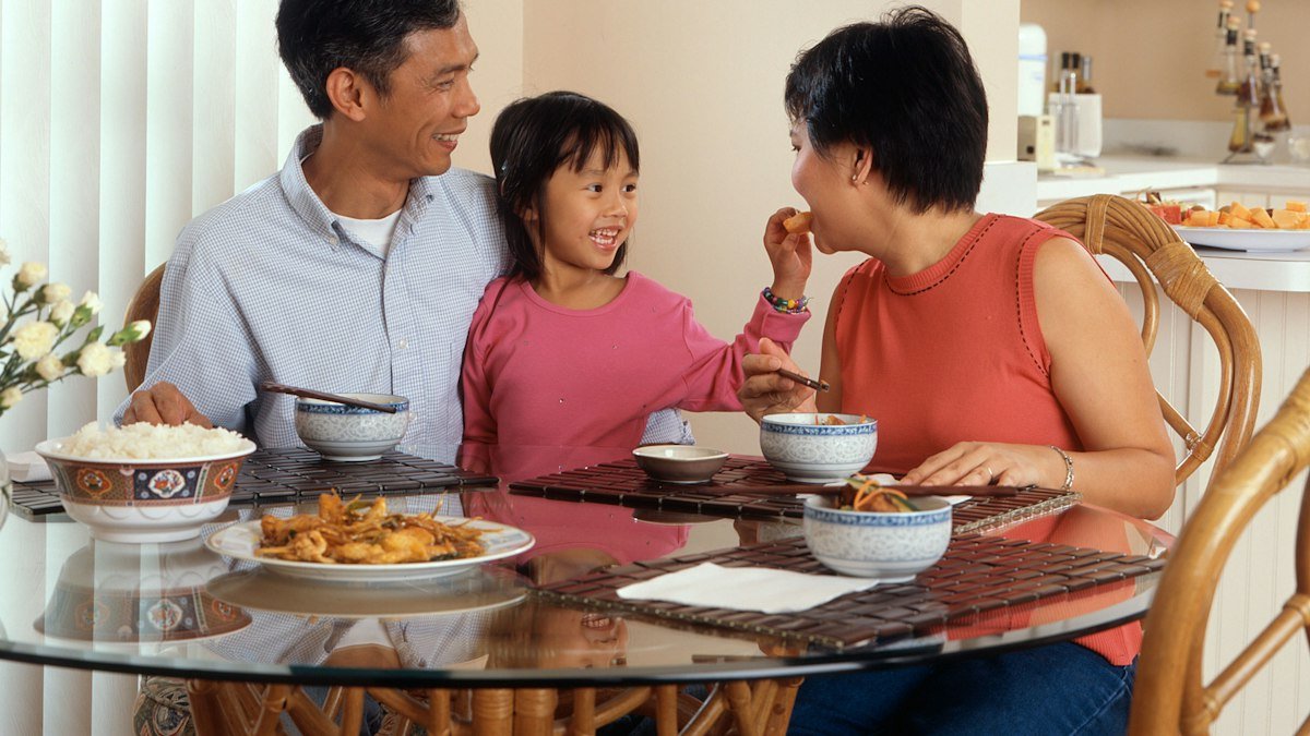 Família reunida à mesa de jantar, retrato de como a renda per capita divide o dinheiro da casa entre todos