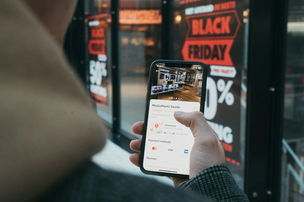 O Que É Cashback e Por Que Ele Pode Fazer Você Gastar Mais Pessoa segurando o celular durante uma compra online com cashback