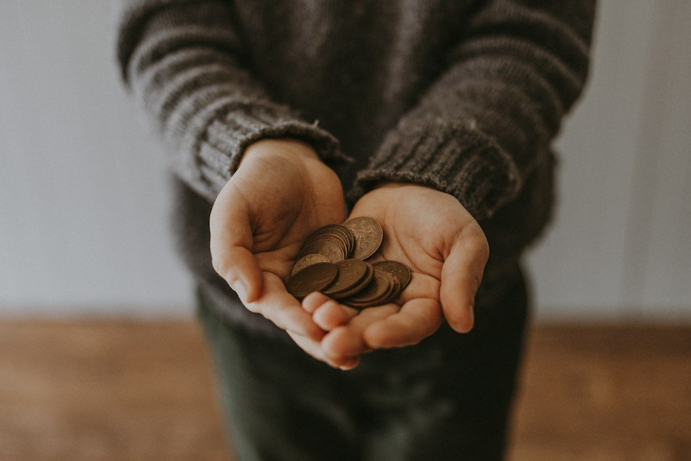 O Que É Cashback e Por Que Ele Pode Fazer Você Gastar Mais Moedas nas mãos representando o dinheiro de volta do cashback